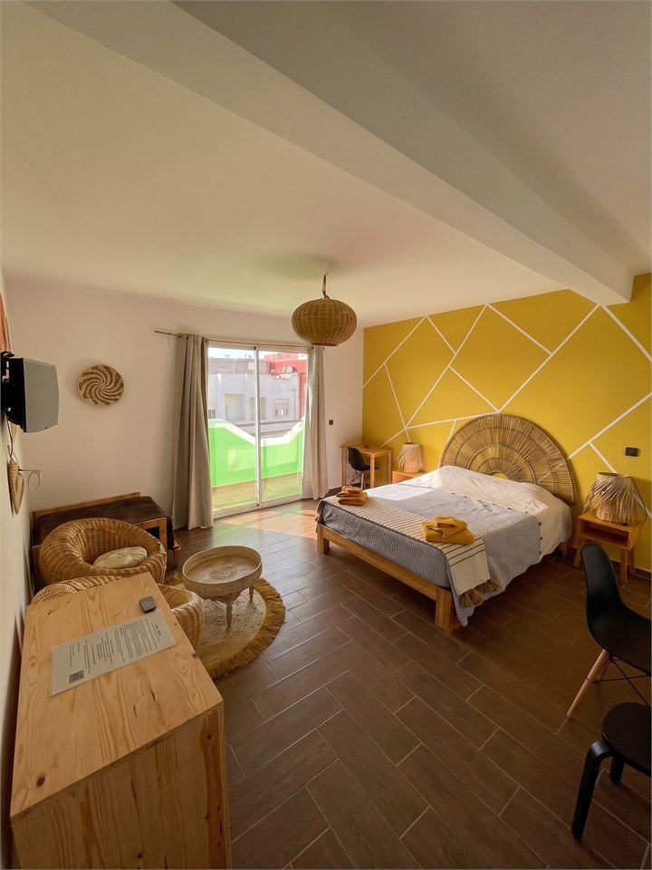 Yellow room at Dar Mouja with balcony, queen bed, and workspace